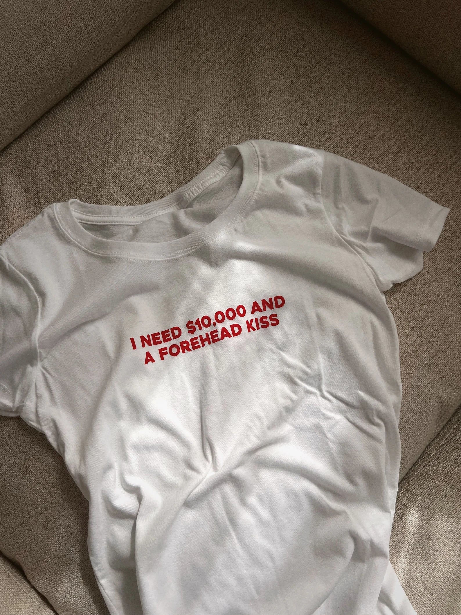 I Need $10,000 and a Forehead Kiss” Baby Tee – Trendy Statement Color White